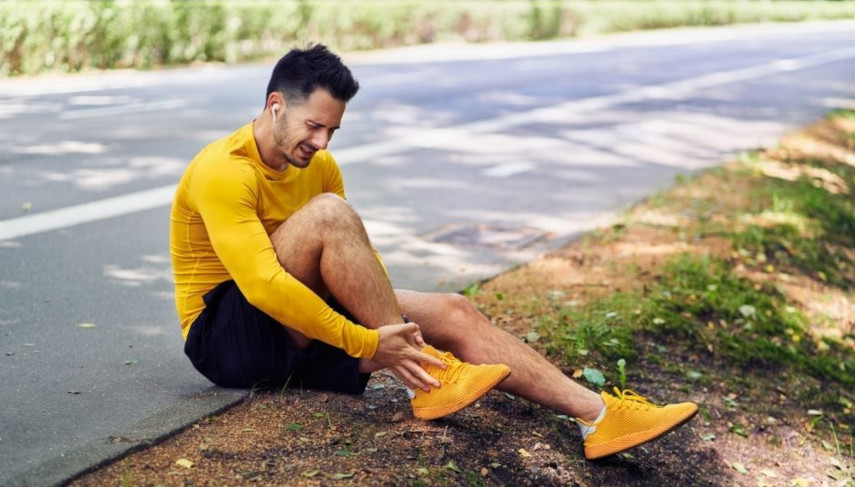 Stukad fotled lopare sitter vid vagkanten